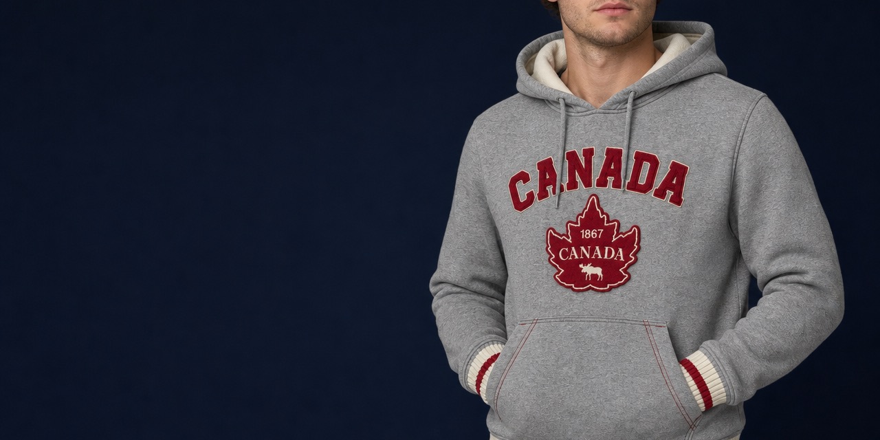 Man wearing a grey Canada hoodie with a burgundy maple leaf appliqué